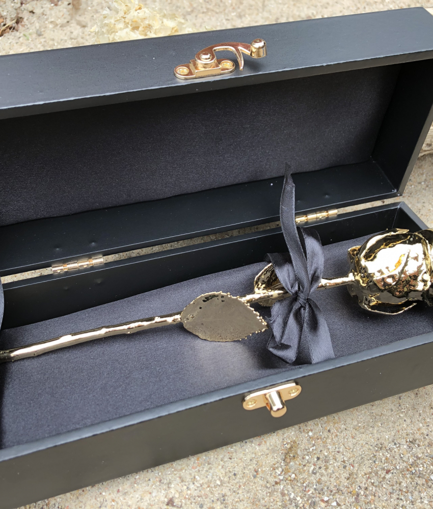 Ægte rose i guld i sort gaveboks på stranden